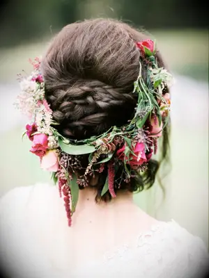 wedding hair flowers low bun surrounded by wildflowers and greenery