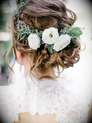 wedding hair flowers low bun with white ranunculus and greenery crown