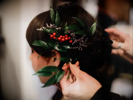 wedding hair flowers winterberry and greens atop low bun