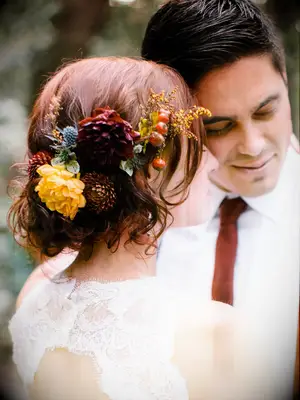wedding hair flowers moody florals above low bun