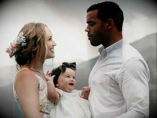wedding hair flowers couple with baby and bride wearing light colored flowers