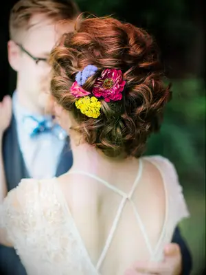 wedding hair flowers colorful florals in low bun