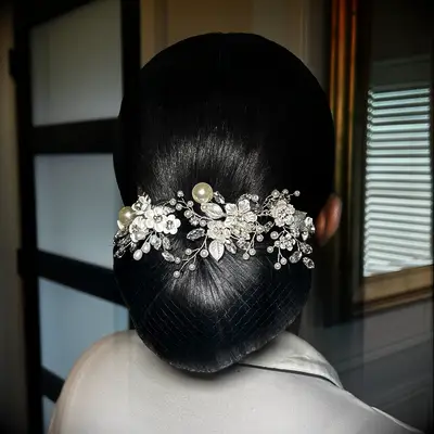Sleek low bun Black wedding hairstyle with silver accessories