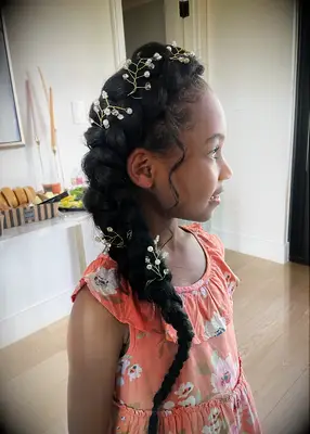 Side-swept braid with gold hair accessories Black wedding hairstyle