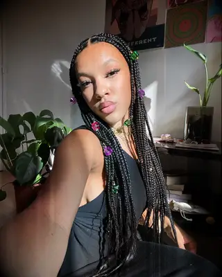 Long braids with center part wedding hairstyle with colorful gem accents