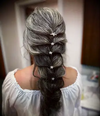 Loose french braid wedding hair style with mini flower details