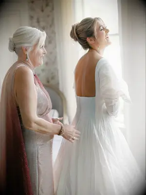 Simple bun with wispy bangs elegant mother of the bride hairstyle