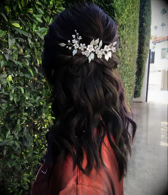 Half up wedding hairstyle with floral hairpiece for medium length hair