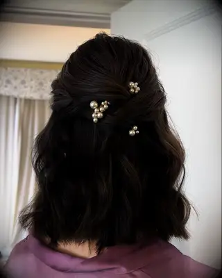 Half-up wedding hairstyle with twists and pearls for medium length hair
