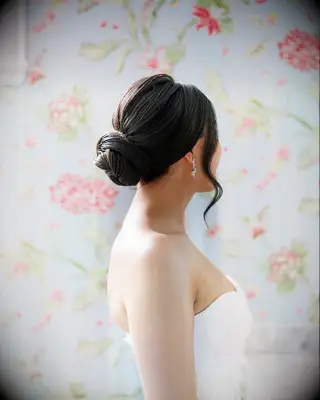Clean low bun with front pieces strapless wedding dress hairstyle