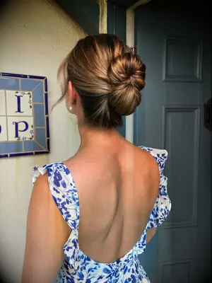 Relaxed infinity bun with face-framing pieces bridesmaid hairstyle