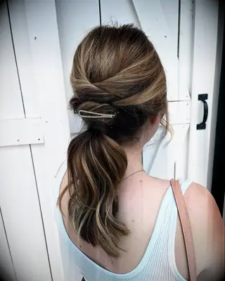 Twisted low ponytail with hair clip wedding hairstyle