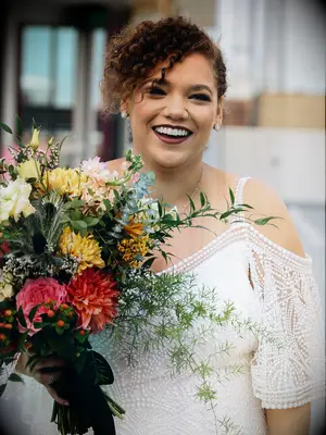 boho wedding hair low bun with curly fringe