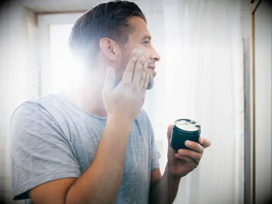 Man applying skincare product to get rid of acne