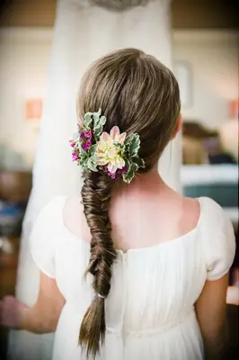 Flower girl wears her hair in an elegant fishtail braid. 