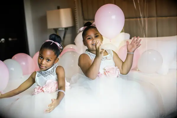 Flower girls wear their hair in sleek top knots. 