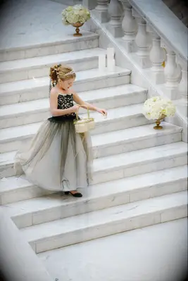 Flower girl wears her hair in an elegant updo with a sparkling tiara. 