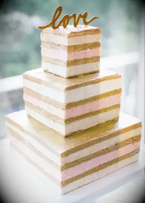 three tier square naked wedding cake with alternating vanilla and strawberry sponge layers