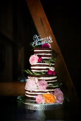 four tier red velvet naked wedding cake decorated with blush and bright pink peonies