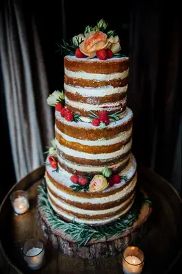 winter naked wedding cake decorated with rosemary leaves and ivory roses