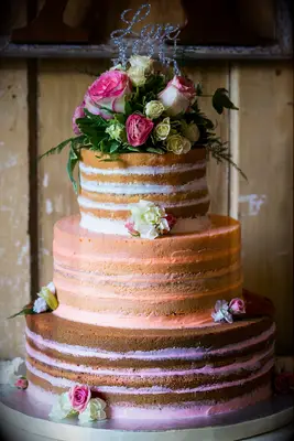 three tier naked wedding cake with ombre white, orange and pink filling