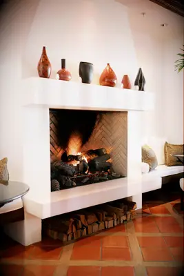 modern wedding fireplace decor idea with terracotta jars on top of large stucco hearth