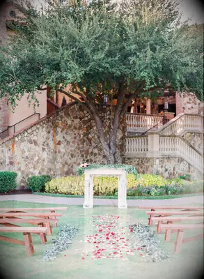 outdoor wedding ceremony with vintage mantel at the altar decorated with greenery and pink flowers