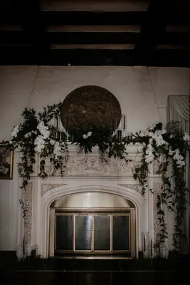 modern wedding fireplace mantel decor with white phalaenopsis orchids and greenery vines