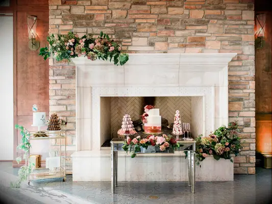 wedding cake table display with stone fireplace as the backdrop
