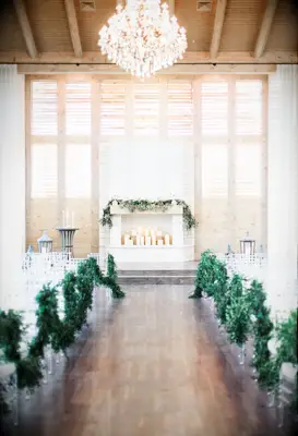 chic wedding fireplace decor with greenery and white candles stacked in different heights