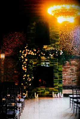 vintage green tiled wedding fireplace decorated with fresh flower arch on one side
