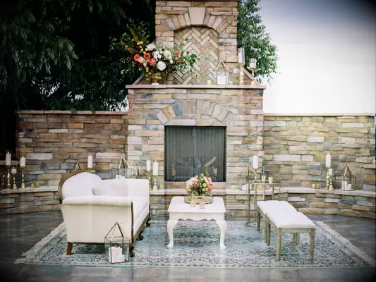 outdoor wedding lounge area with brick fireplace in the background