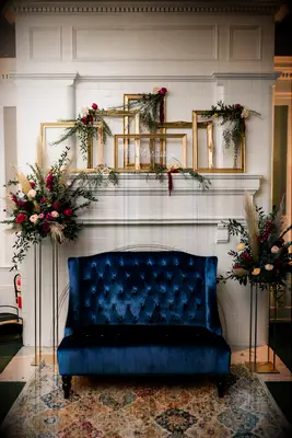 boho wedding fireplace decor idea with mismatched rectangular gold picture frames 