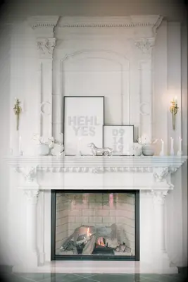 modern wedding fireplace decor with monochromatic white and silver flowers, candles and signs