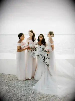 Bridesmaids and bride posing in front of scenic waterfront