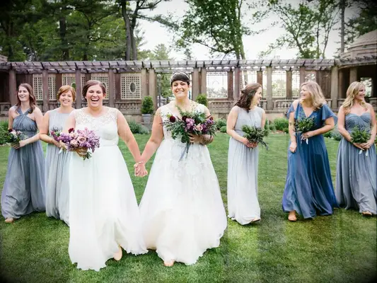 Brides walking to ceremony with bridesmaids