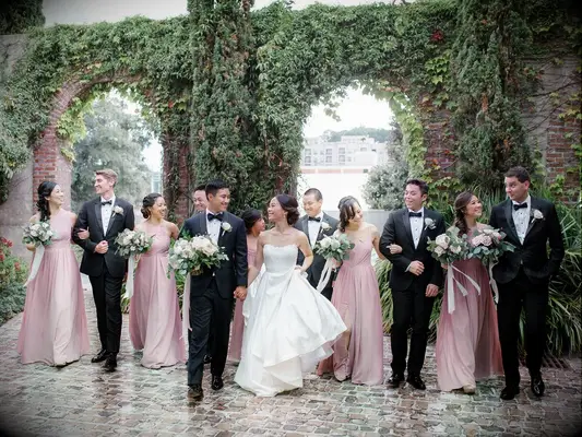 Bridesmaid picture with groomsmen at outdoor venue