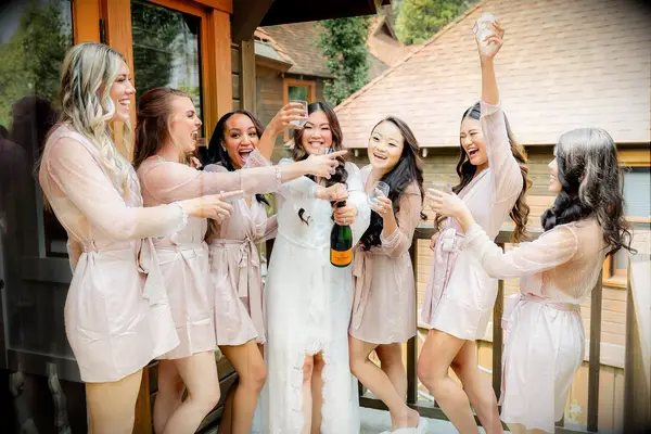 Bridesmaids and bride dancing and laughing with champagne