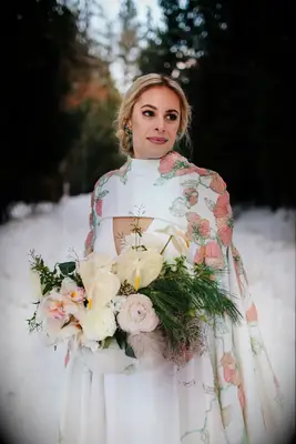 bride holding winter wedding bouquet outside in the snow