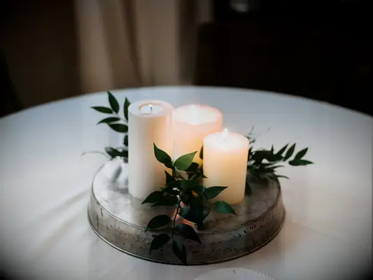 simple greenery centerpiece with white pillar candles and smilax vines