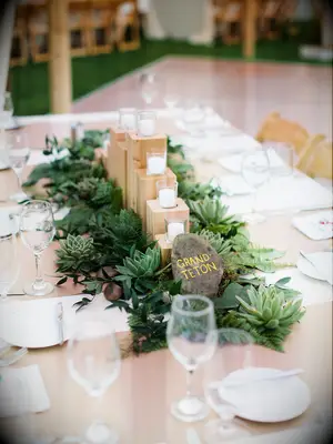 wedding centerpiece with wooden votive candle holder surrounded by succulents