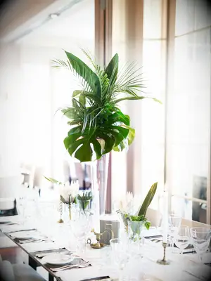 tall wedding centerpiece with monstera leaves and tropical greenery