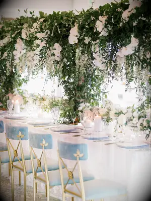 long wedding reception table with tall hanging greenery centerpieces