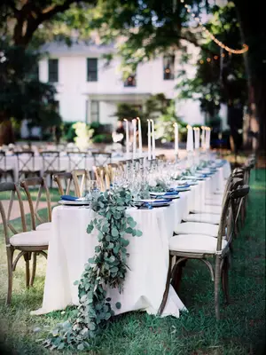 elegant outdoor wedding reception tablescape with eucalyptus runner