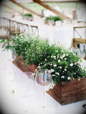 low wedding centerpiece with greenery and wooden box vessel