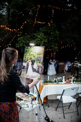 Live painter works on a romantic scene of the newlyweds in a sweet embrace. 