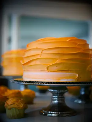 orange buttercream wedding cake on a silver cake stand