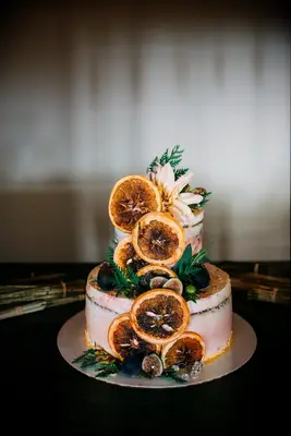 two tier fall wedding cake with dried orange slices and greenery