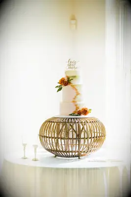 rustic boho fall wedding cake with ombre fondant displayed on rattan ottoman stand