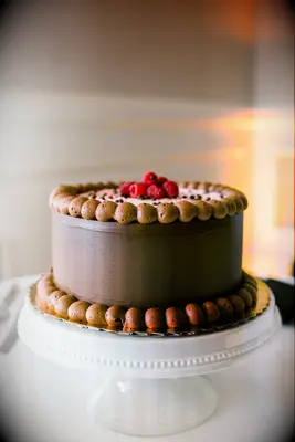 chocolate buttercream wedding cake topped with fresh raspberries